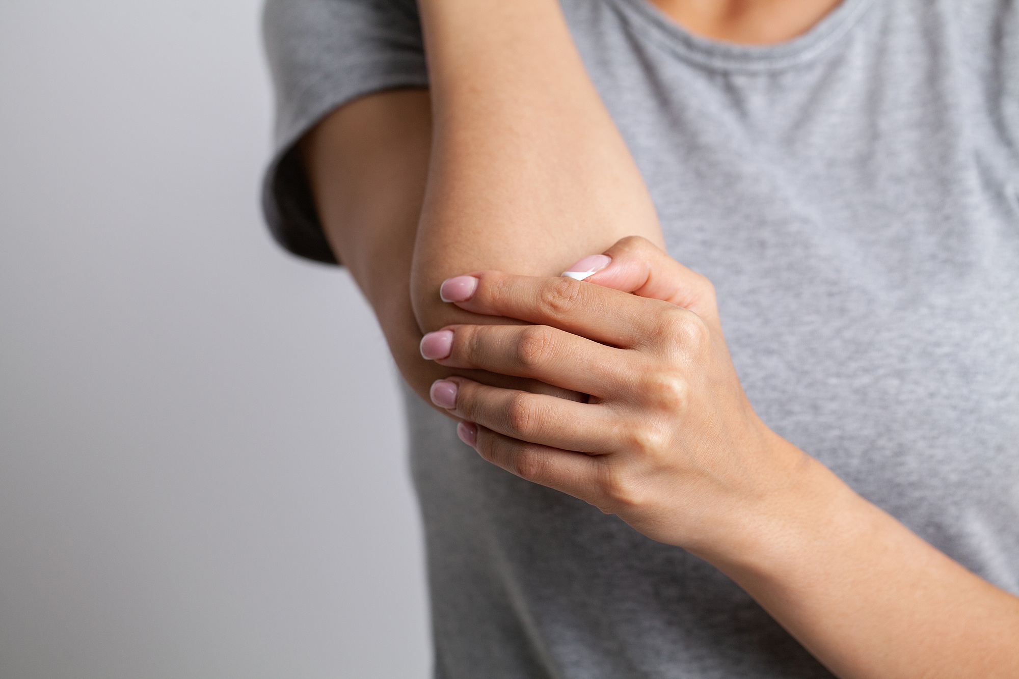 elbow pain woman suffering from elbow pain on gray background
