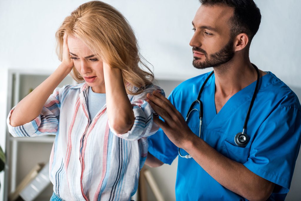 Pain management doctor examining a woman patient.