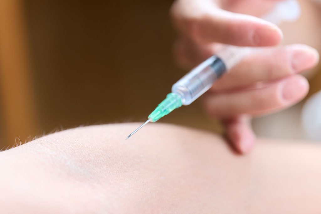 Doctor making an injection in arm.