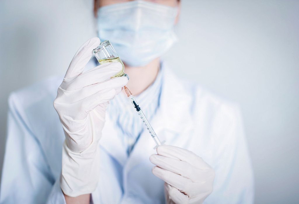 Woman doctor holding vaccine.